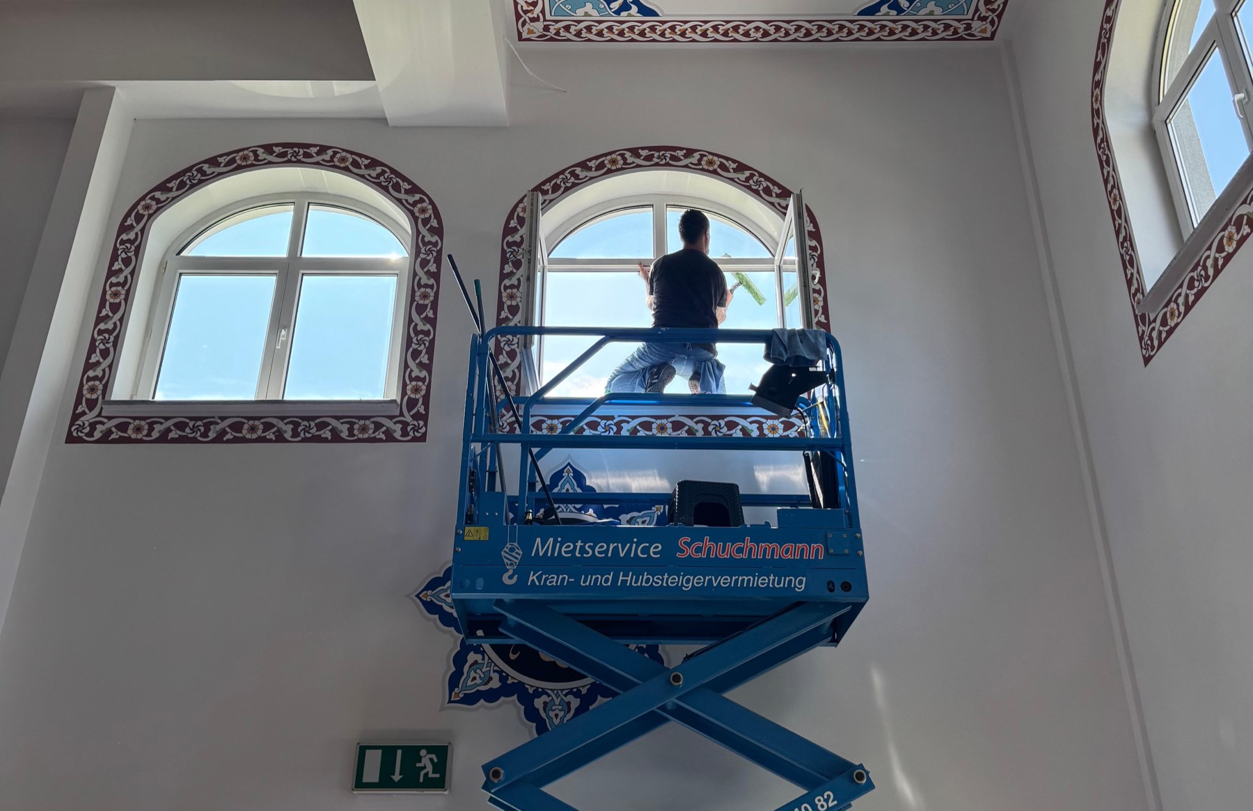 Mitarbeiter auf der Hubarbeitsbühne bei der Glasreinigung