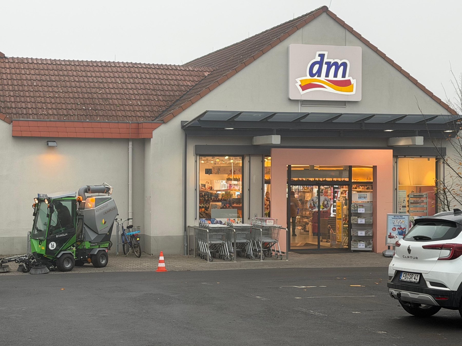Kehrmaschine bei der Flächenreinigung vor einer dm-Filiale